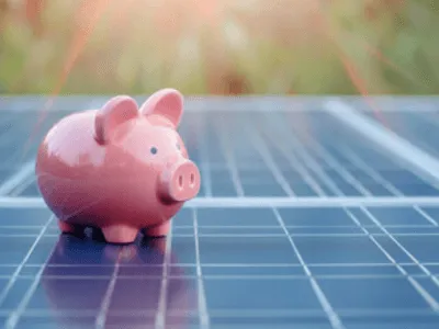 un salvadanaio a forma di porcellino rosa su un pannello fotovoltaico