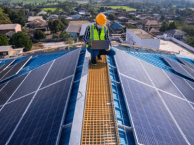 un operaio si occupa di un impianto fotovoltaico su un tetto