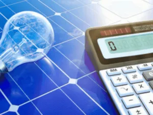 una calcolatrice e una lampadina su un pannello fotovoltaico