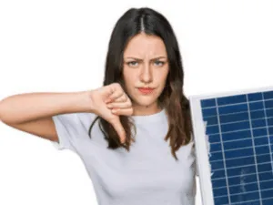 una donna col pollice all'ingiù con un pannello fotovoltaico in mano